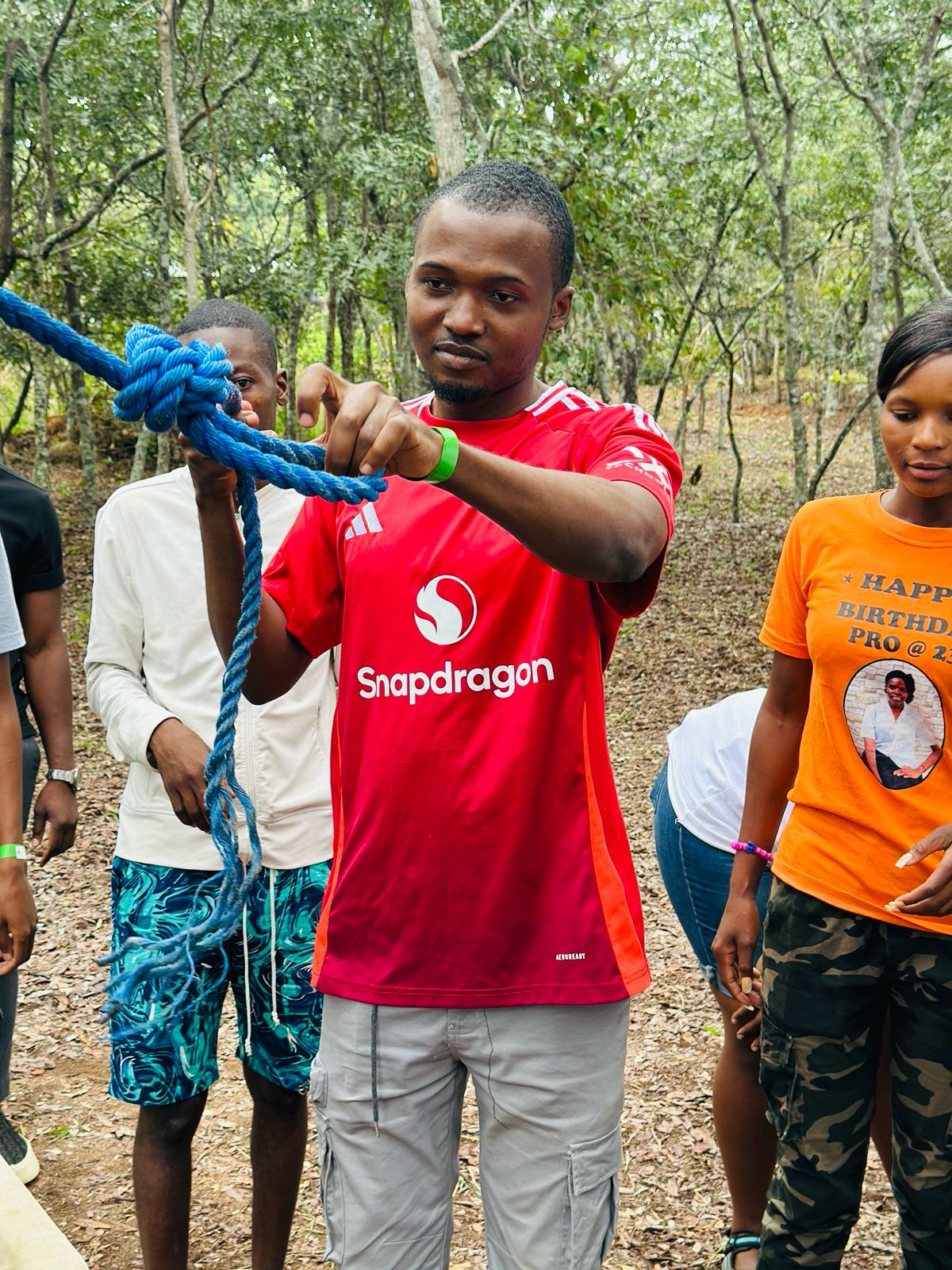 Camp participants learning to tie a rope during an outdoor team activity
