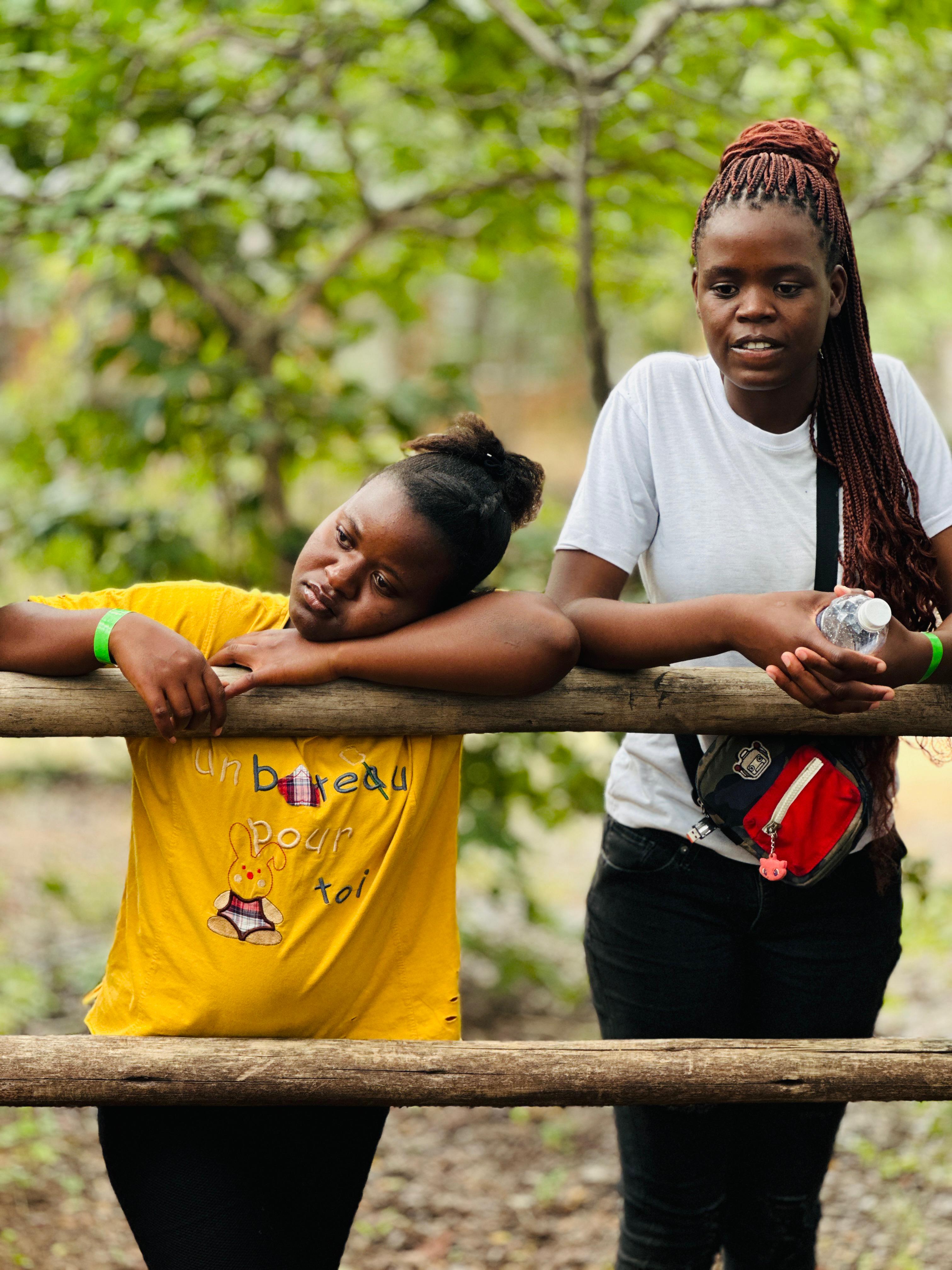 Friends smiling and laughing together among the trees at camp