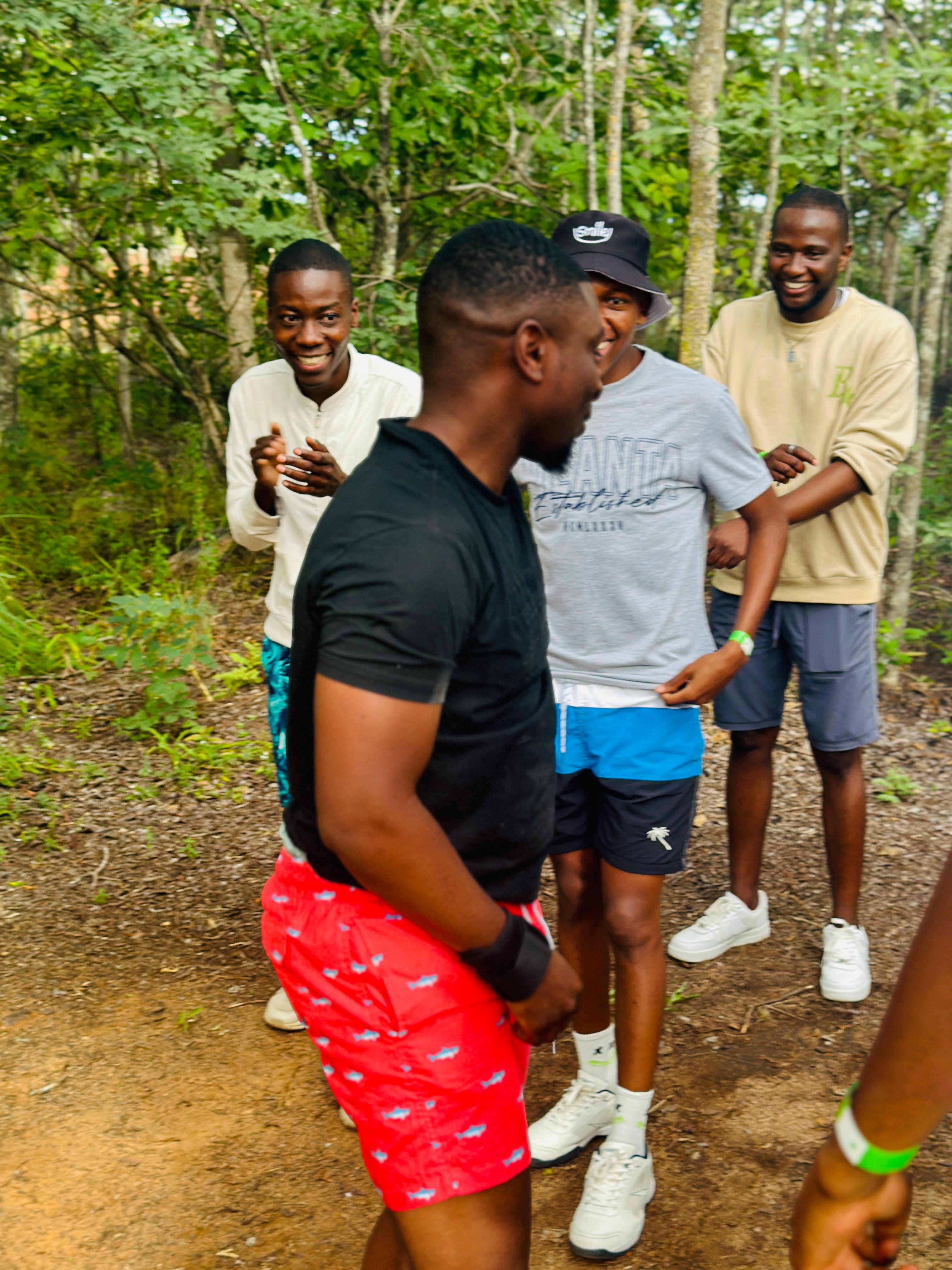 Camp team lifting a participant's foot to help him through an obstacle