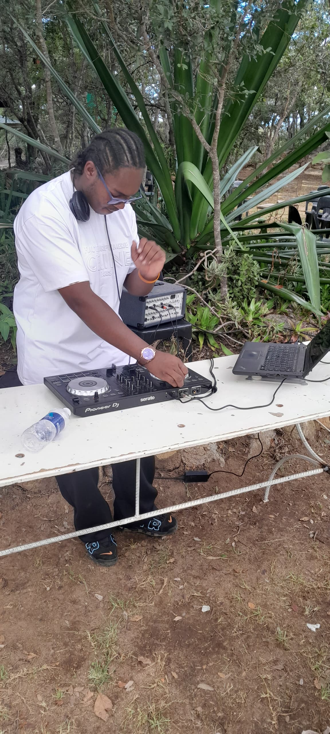 Camp DJ mixing music at an outdoor sound table