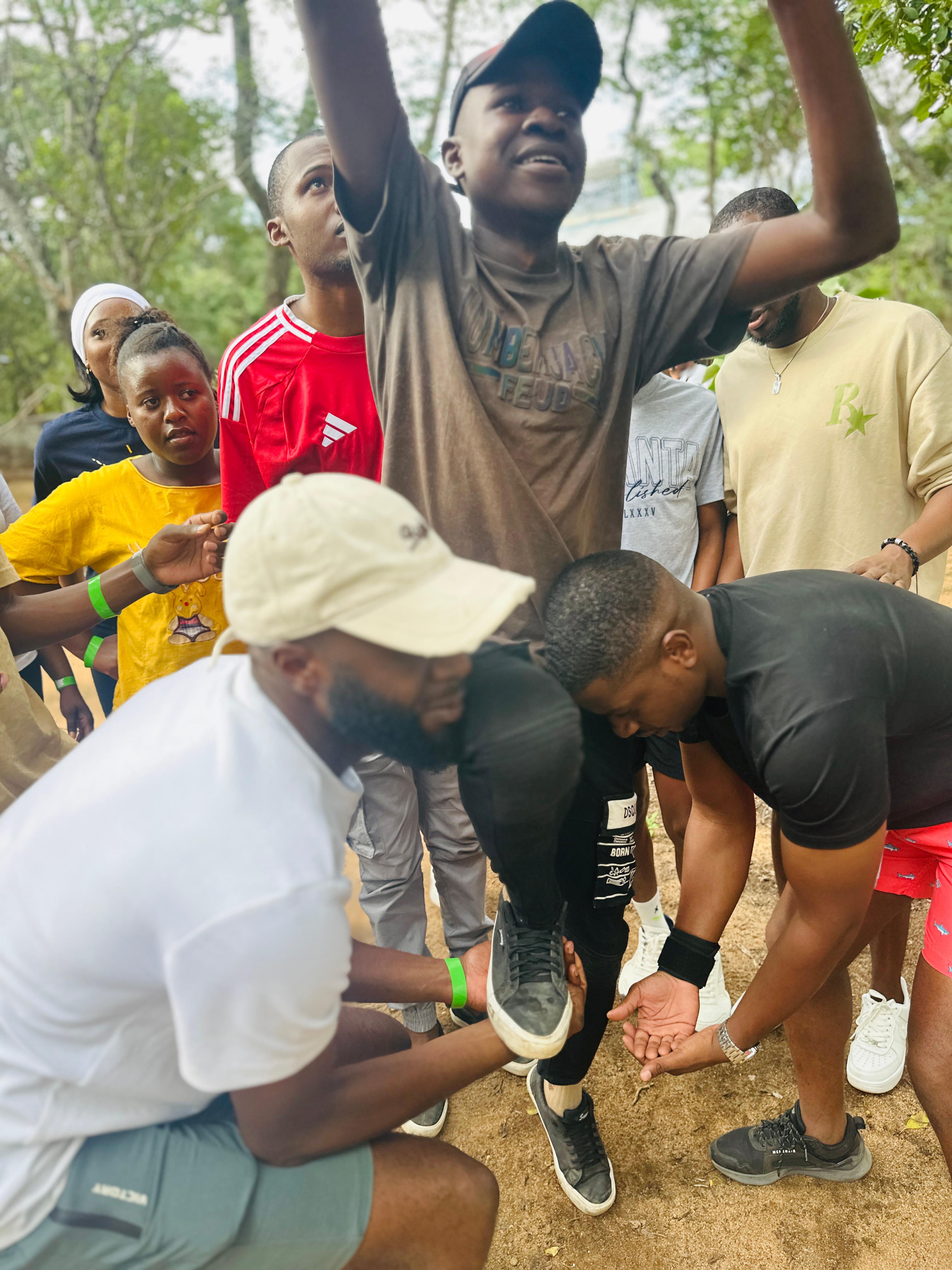 Camp participants huddled together during an outdoor team challenge