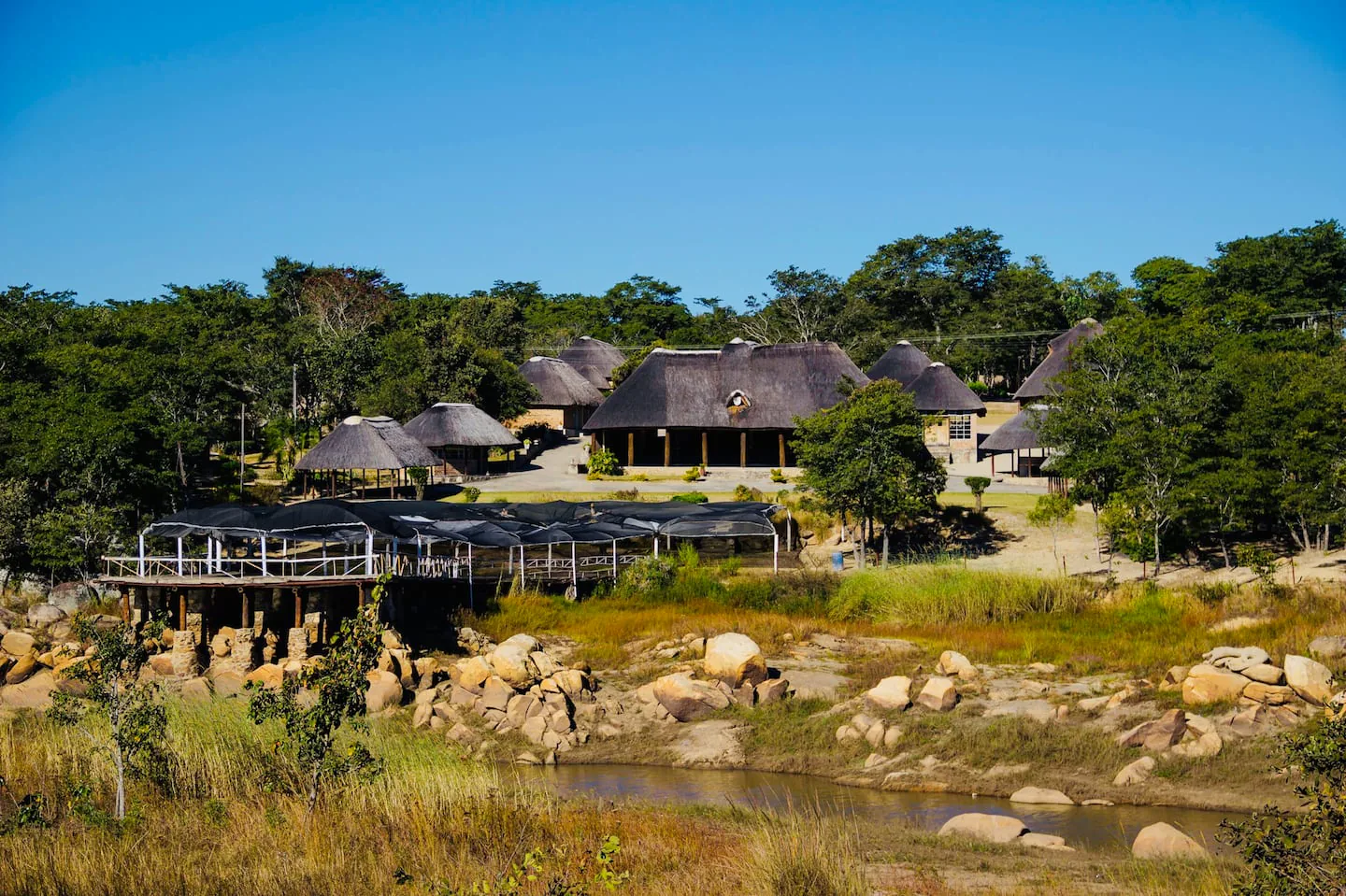 Karumazondo Resort grounds and thatched lodges beside the dam