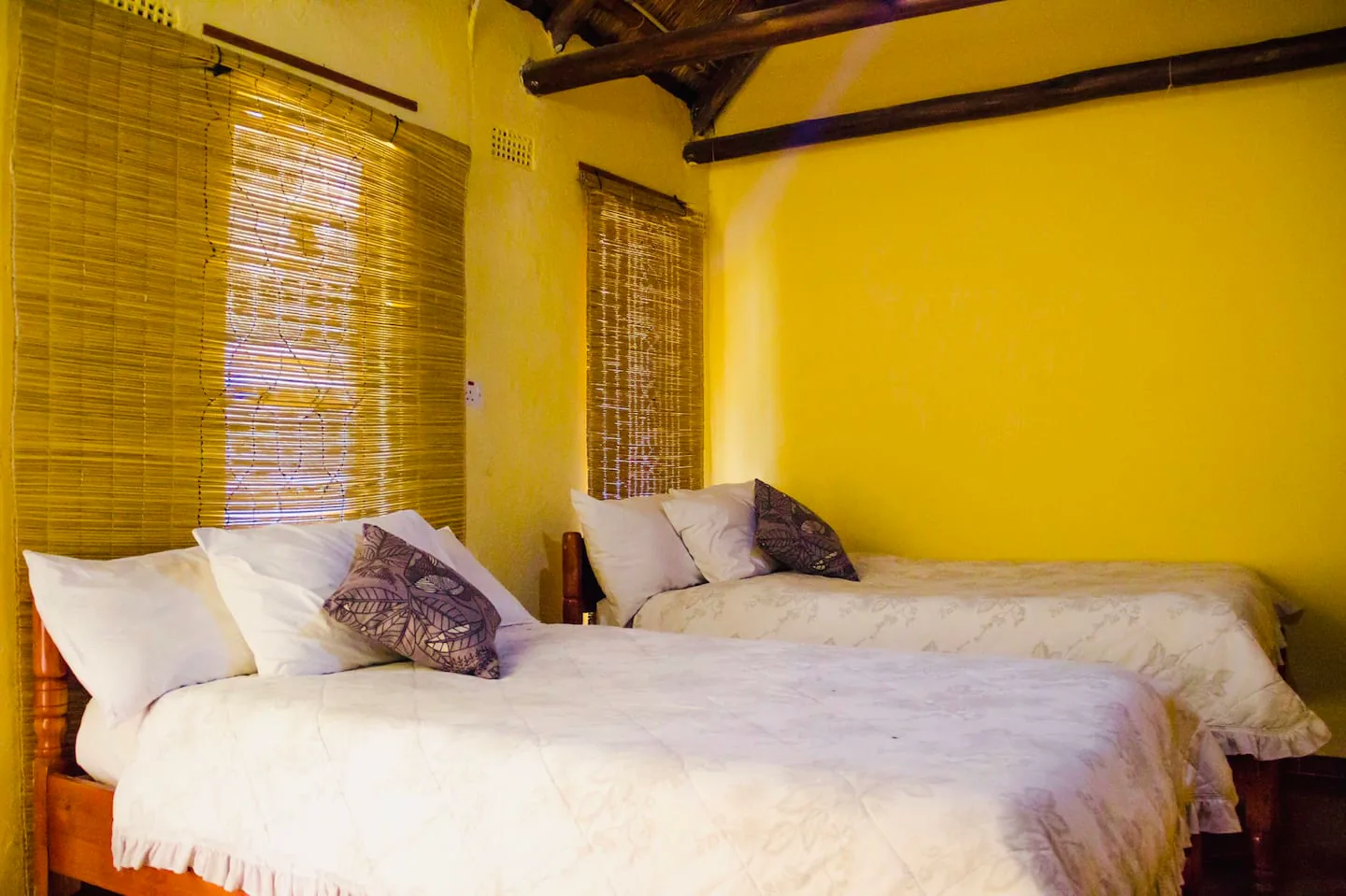 Twin bedroom with white bedding inside Karumazondo Resort accommodation